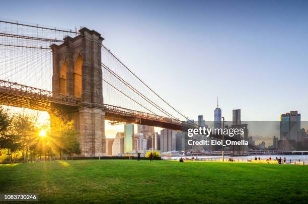 ブルックリン ブリッジと夕暮れ時のマンハッタン。ニューヨーク - nyc building sun ストックフォトと画像