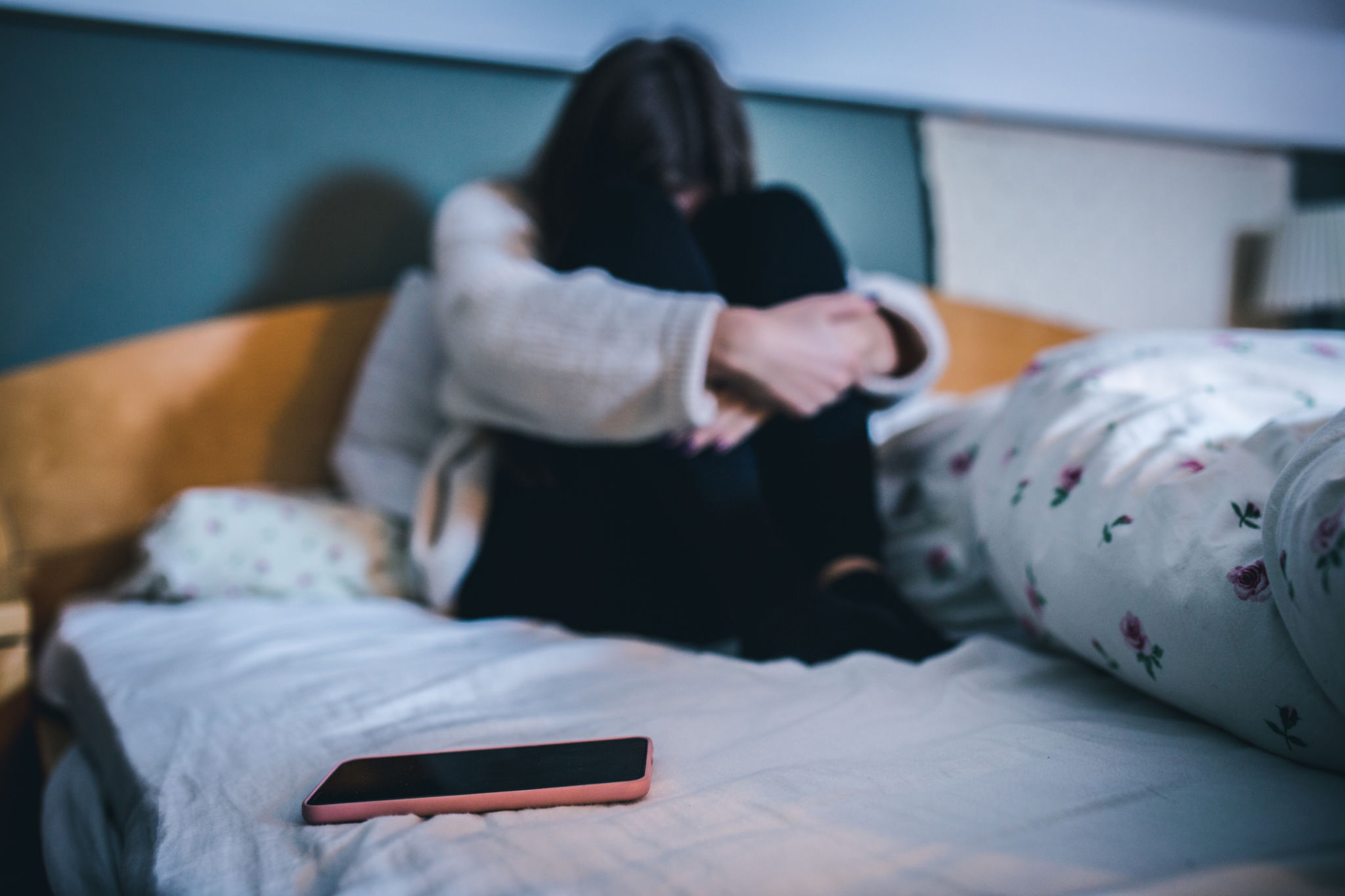 Sad teen with a phone in her bedroom Sad teen with a phone in her bedroom