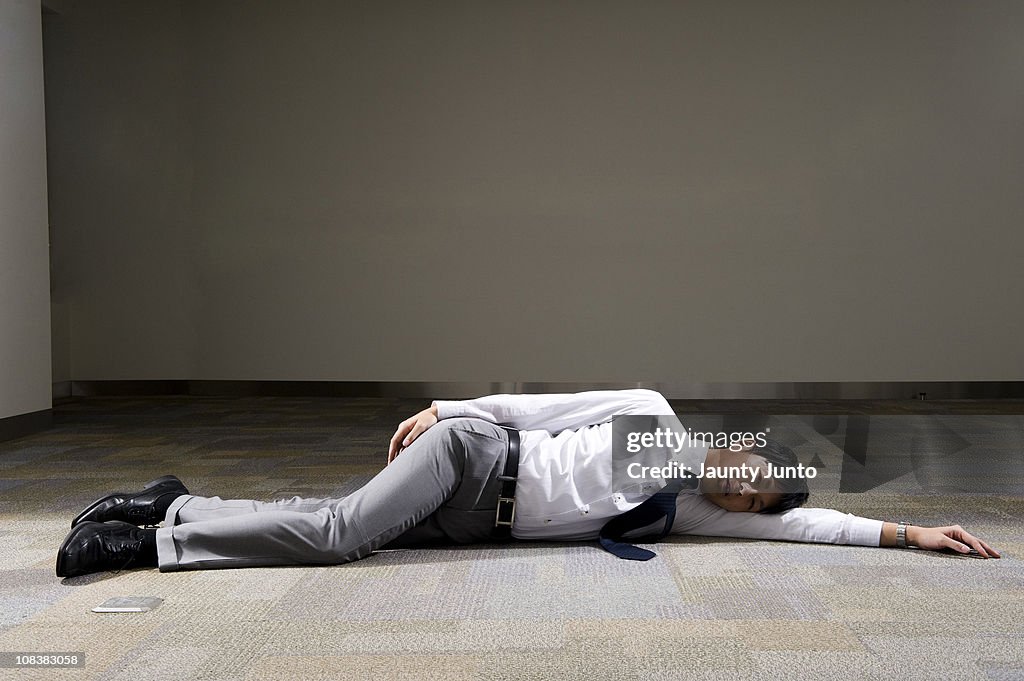 Business man laying down on the floor