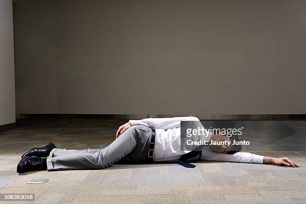 business man laying down on the floor - lying down stockfoto's en -beelden