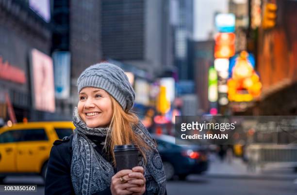 vrouw met koffie op times square in new york. - museum of the city of new york winter ball stockfoto's en -beelden