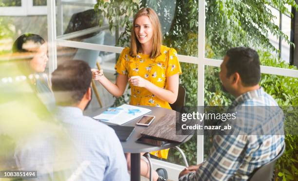 confident woman taking lead role in business meeting. - new zealand yellow stock pictures, royalty-free photos & images