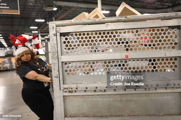 Postal service mail handler Joycelyn Brown prepares a box full of packages for sorting at the U.S. Postal service's Royal Palm Processing and...