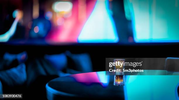 nightclub bar scene of abstract nightlife with candle and table at restaurant - food photography dark background blue stock-fotos und bilder
