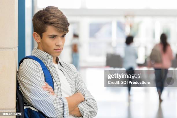 boze mannelijke middelbare schoolstudent staat in lobby - angry boy stockfoto's en -beelden