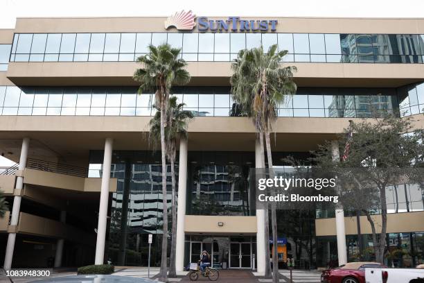Person rides a bicycle in front of a SunTrust Banks Inc. Branch in St. Petersburg, Florida, U.S., on Monday, Jan. 14, 2019. SunTrust Banks Inc. Is...