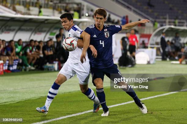 Azizbek Turgunbaev of Uzbekistan and Sho Sasaki of Japan compete for the ball during the AFC Asian Cup Group F match between Japan and Uzbekistan at...