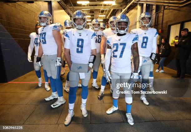 Matthew Stafford of the Detroit Lions and Glover Quin and Kenny Wiggins and Matt Cassel stand and wait in the tunnel before taking the field for the...