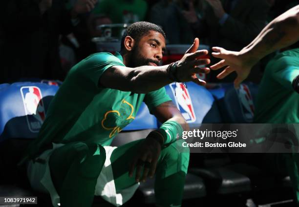 Boston Celtics' Kyrie Irving gives a hand to a teammate during pre-game player introductions. The Boston Celtics host the Toronto Raptors in a...