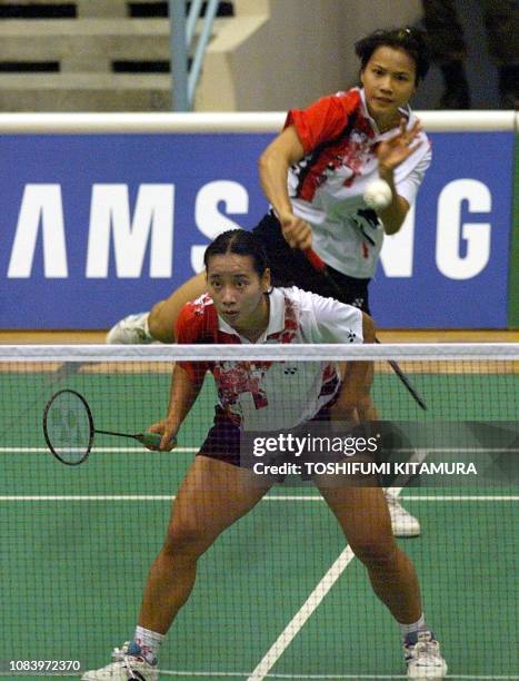 Deyana Lomban of Indonesia smashes a shuttle while her partner Elysa Nathanael takes position during their doubles match against Malaysia's Lim...