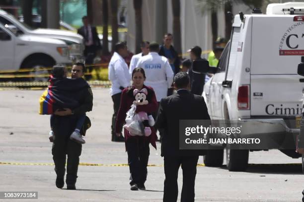 People affected by an explossion at the police cadet training school in Bogota, evacuate the area where an apparent car bomb attack left at least...