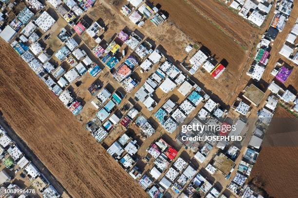 An aerial view shows an informal tent settlement housing Syrian refugees in the area of Delhamiyeh, in the central Bekaa Valley on January 17, 2019....