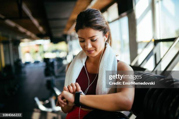 sportieve vrouw controleren de tijd op het horloge - mens wrist watch stockfoto's en -beelden