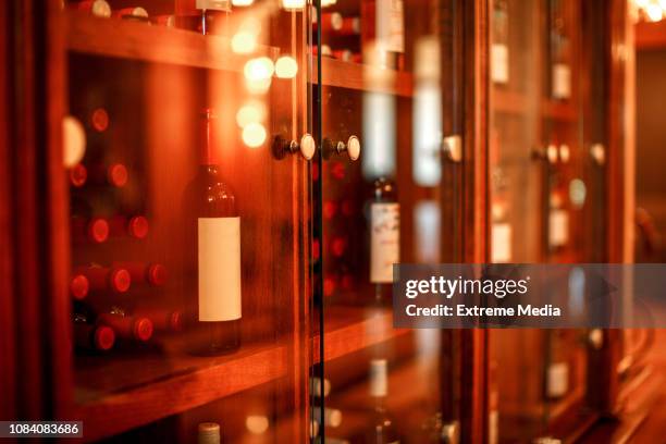 中にワインのボトルとガラスの扉とワイン キャビネットが積まれて - ワインセラー ストックフォトと画像