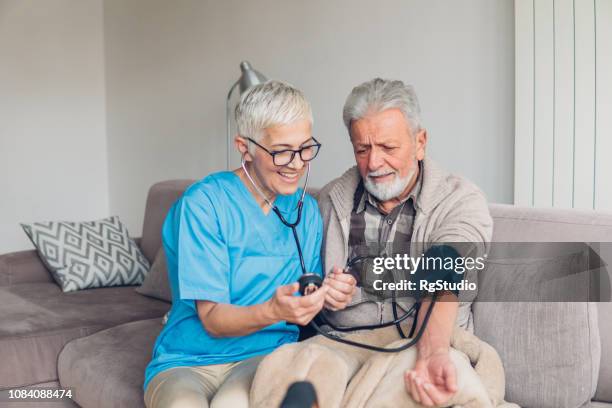 male patient having blood pressure taken - happiness meter stock pictures, royalty-free photos & images