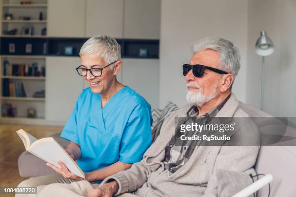 happy woman reading to the blind - blind person stock pictures, royalty-free photos & images