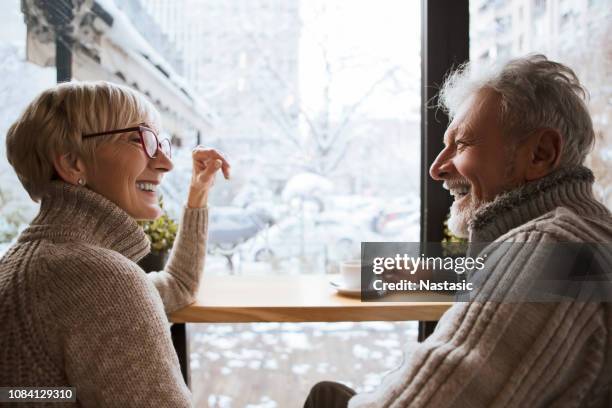 smiling seniors enjoin cup of coffee - senior women cafe stock pictures, royalty-free photos & images