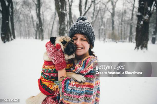 woman and dog enjoying snow on winter holidays - winter dog stock pictures, royalty-free photos & images