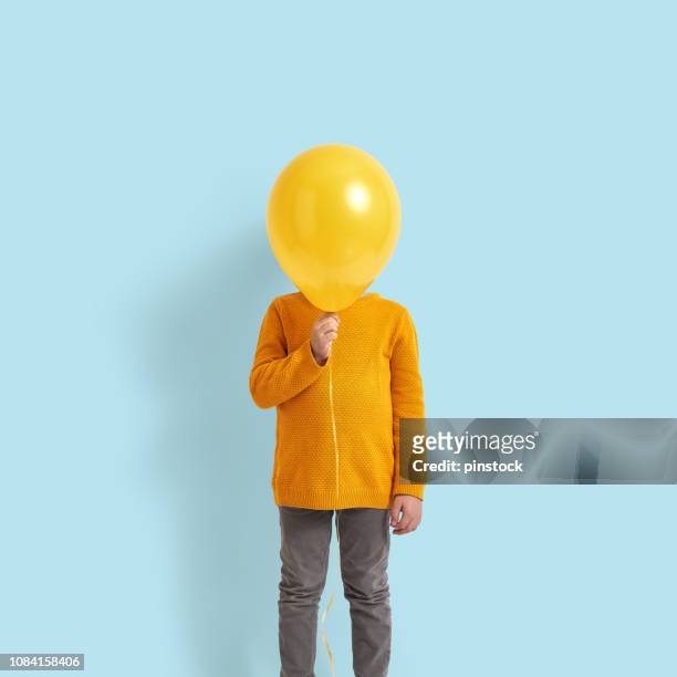niedlichen kind hält einen gelben ballon - kids creativity stock-fotos und bilder
