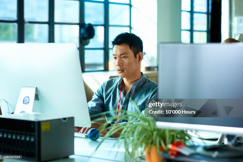 Mid adult man using computer and concentrating