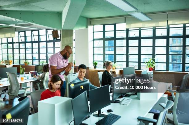 occupational therapist making notes and observing staff at work station - occupational health and safety stock pictures, royalty-free photos & images