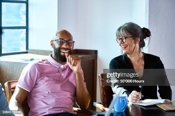 cheerful mature businesswoman laughing with male coworker - male friendship - fotografias e filmes do acervo