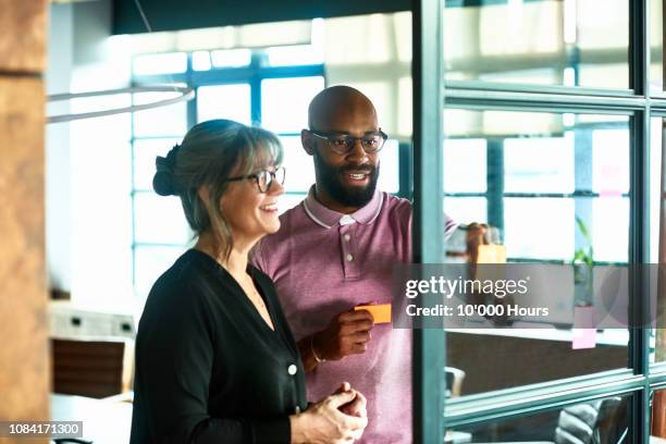two colleagues using sticky notes during brainstorming session - thinking outside the box expressão inglesa imagens e fotografias de stock