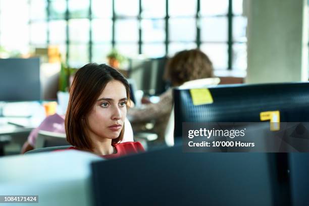 portrait of young woman staring at computer screen in office thinking - staring at screen stock pictures, royalty-free photos & images