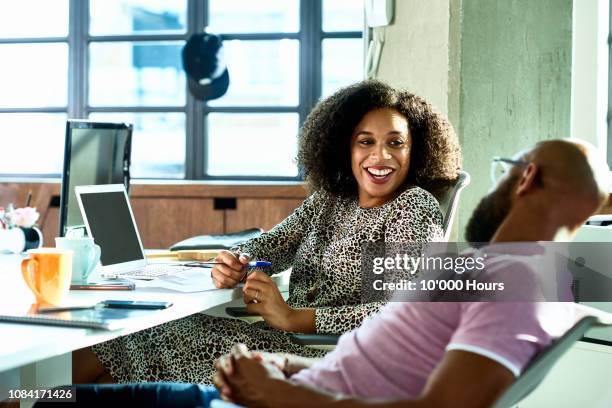 cheerful male and female friends chatting in office and smiling - portrait woman men looking at each other stock-fotos und bilder