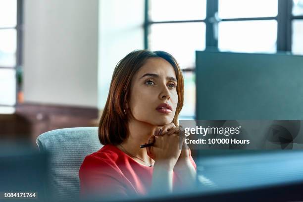 candid portrait of hispanic businesswoman deep in thought at desk - contemplation stock pictures, royalty-free photos & images