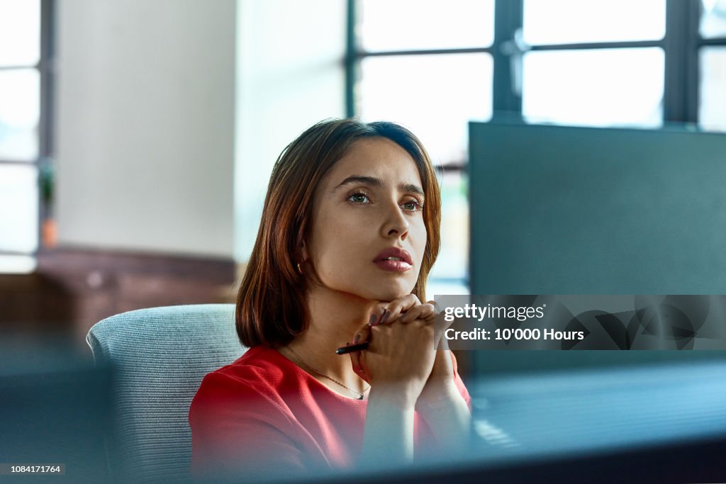 Candid portrait of Hispanic businesswoman deep in thought at desk