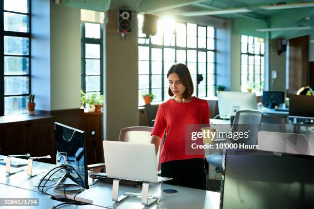 female office worker switching on computer to start her working day - morning bildbanksfoton och bilder