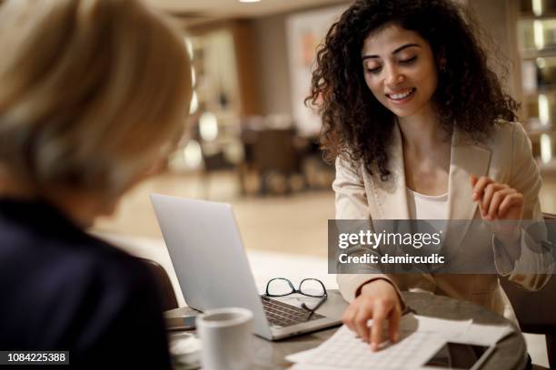 zakelijke bijeenkomst - woman filling out paperwork stockfoto's en -beelden