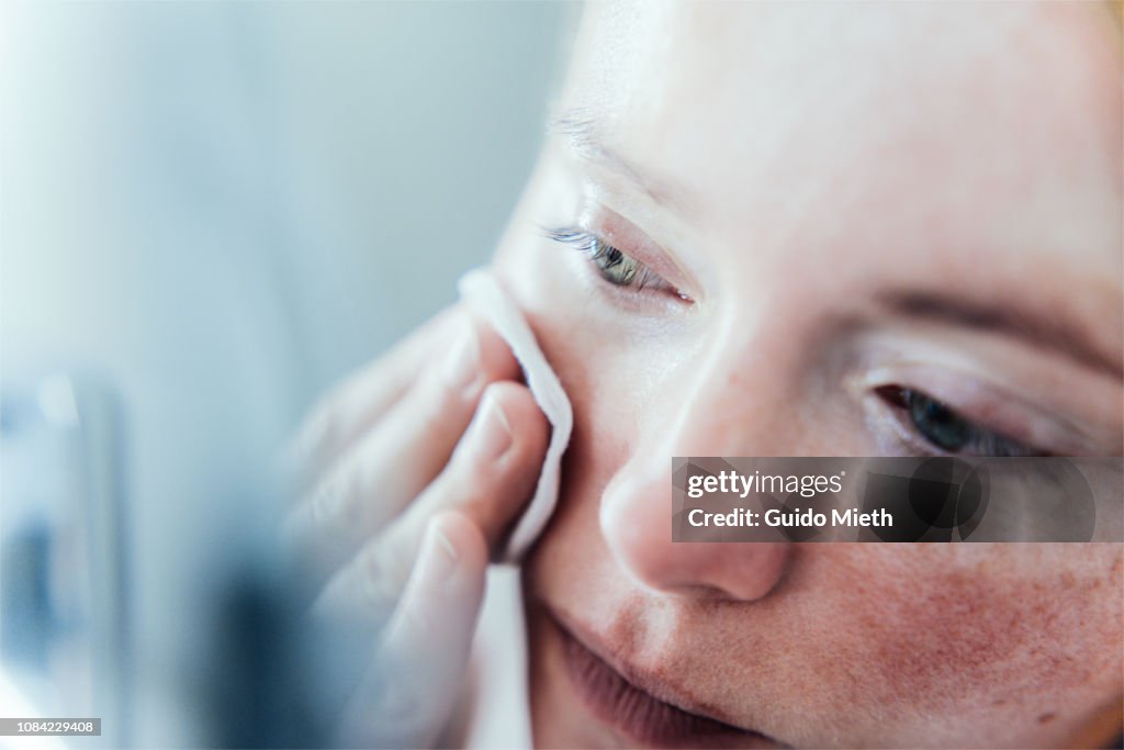 Woman cleaning her face.