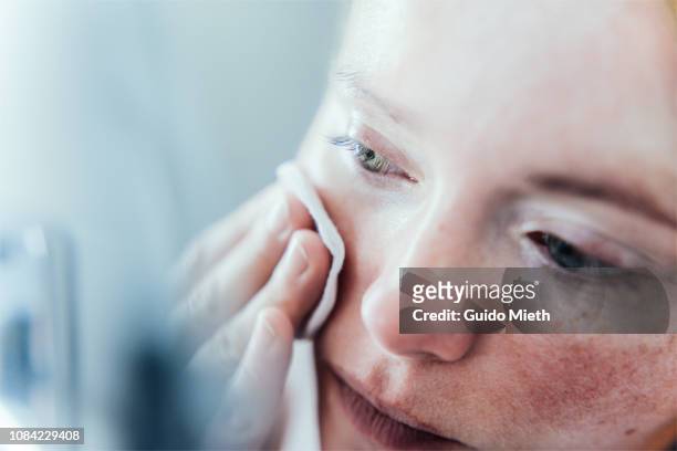 woman cleaning her face. - lichaamsverzorging en schoonheid stockfoto's en -beelden