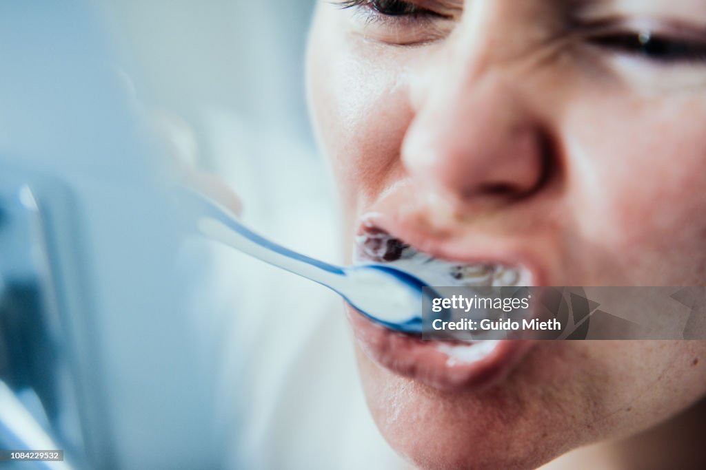 Woman brushing teeth.