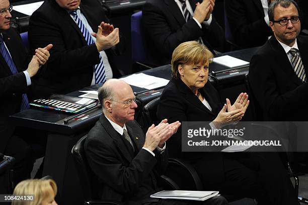 German Chancellor Angela Merkel and the President of the Parliament Norbert Lammert applaud after Dutch-born Roma Holocaust survivor Zoni Weisz...