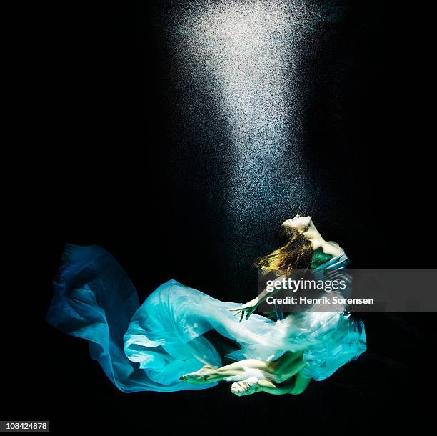 adult female under water in flowing evening dress - woman in evening dress stock-fotos und bilder