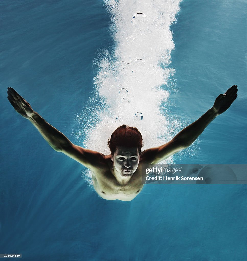 Male swimmer under water with bubbles