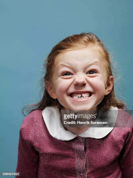 portrait of young girl pulling a face - clenching teeth stock-fotos und bilder