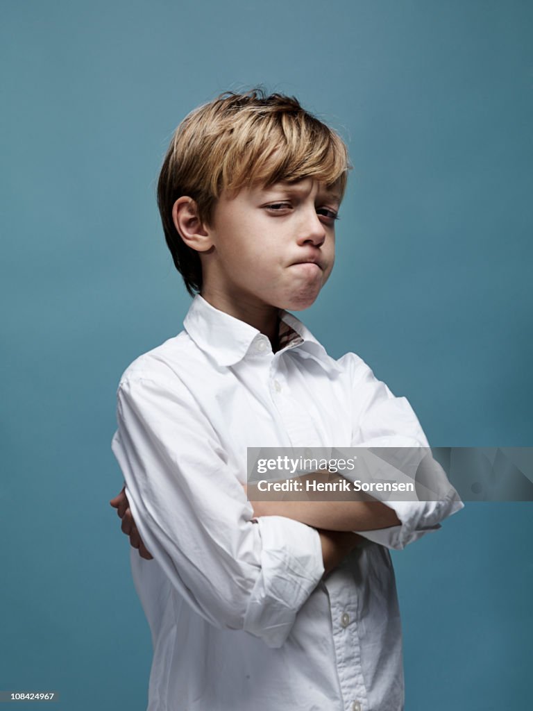 Portrait of young boy with crossed arms and looks