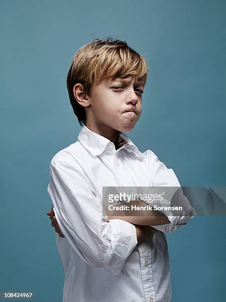 portrait of young boy with crossed arms and looks - children misbehaving stock pictures, royalty-free photos & images