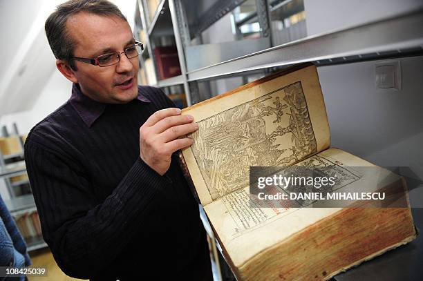 (To go with AFP story by Isabelle WesselinghFather Lucian Dinca shows a Ukrainian prayer book from 1646 at the Institute of Byzantine Studies in...