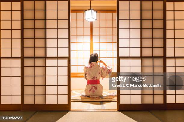 woman brushing hairs in a traditional ryokan - japansk skjutdörr bildbanksfoton och bilder