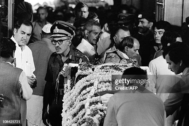 Assassinated Prime Minister Indira Gandhi lies in state at Teen Murti Bhavan on October 31, 1984 in New Delhi, as her son Rajiv Gandhi looks on....