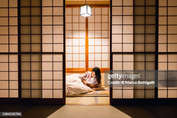 woman working with tablet computer in a traditional ryokan - porta di carta giapponese foto e immagini stock