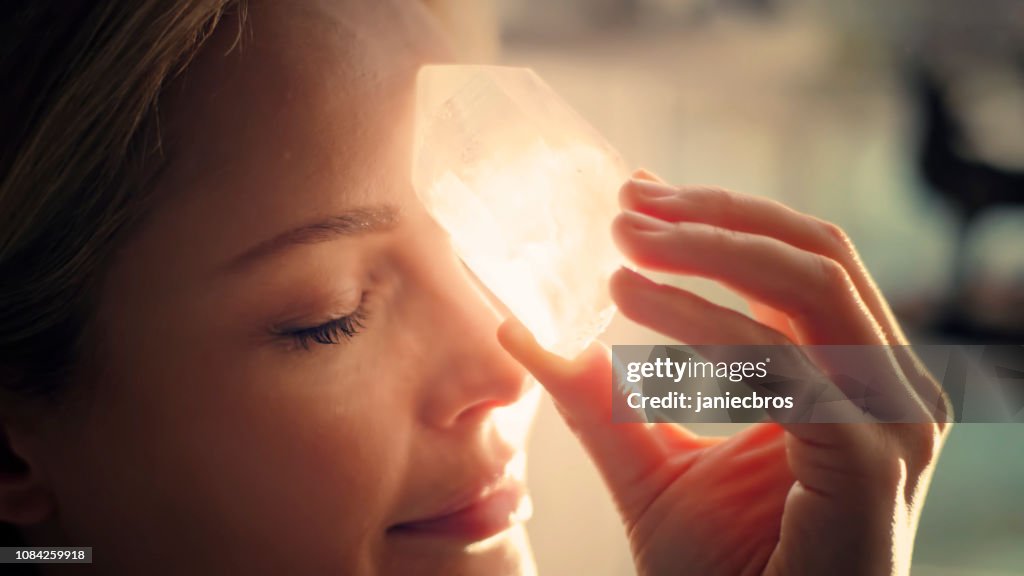 Woman's head with a healing crystal.