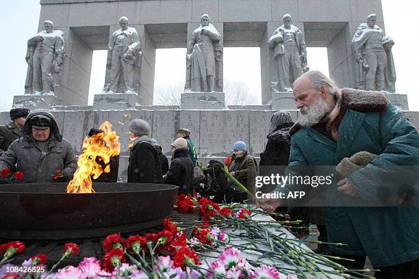 People pay lay flowers at a memorial for victims of the 1941-1944 Nazi siege of Leningrad at the Serafimovskoye cemetery in Saint- Petersburg on...