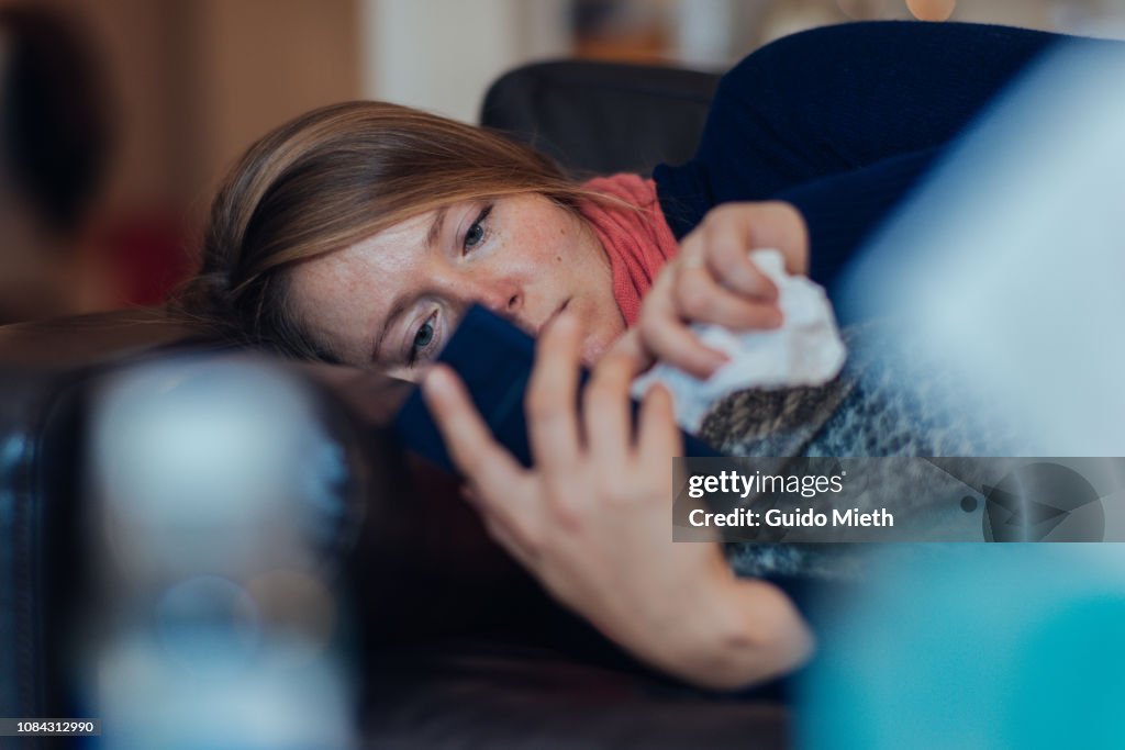 Ill woman using mobile phone.