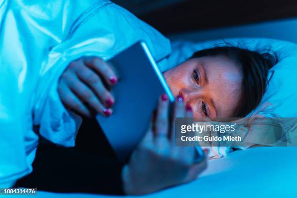 woman using tablet pc in bed. - binge watching stock pictures, royalty-free photos & images